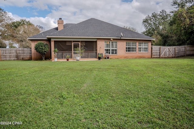 rear view of property featuring a yard and a sunroom