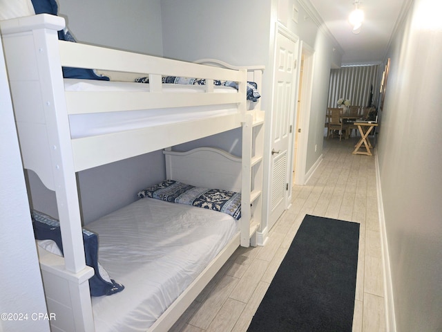 bedroom with crown molding and light hardwood / wood-style flooring