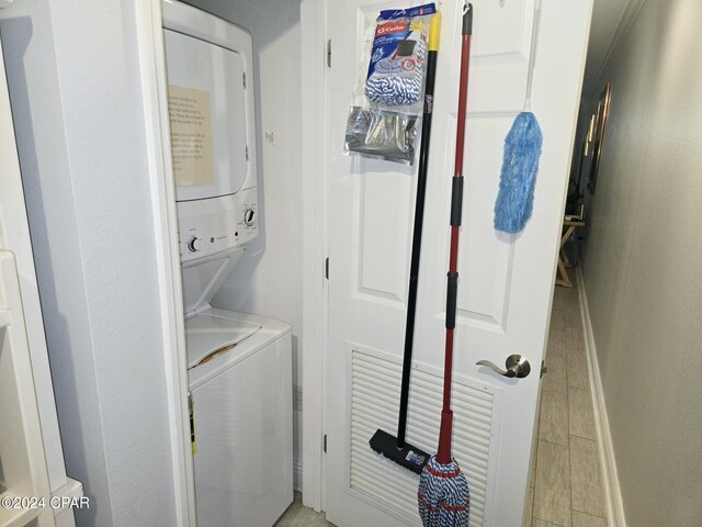 laundry area featuring light hardwood / wood-style floors and stacked washer and clothes dryer