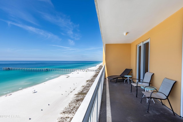 balcony featuring a water view and a beach view