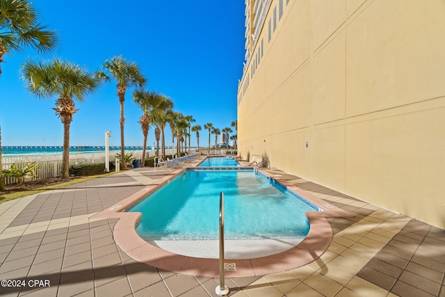 view of pool with a patio and a water view