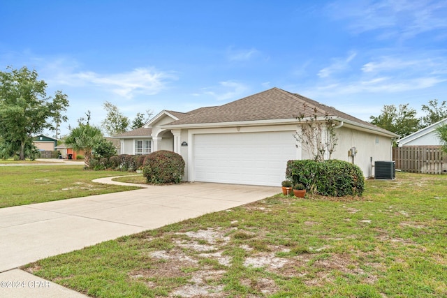 single story home featuring central air condition unit, a front yard, and a garage