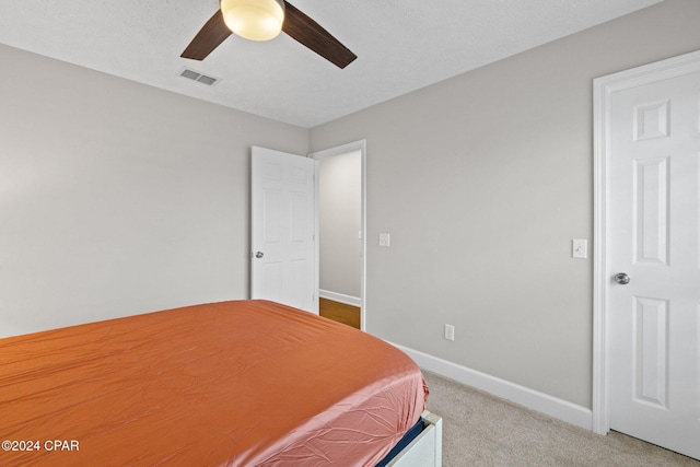 bedroom featuring carpet flooring, ceiling fan, and a textured ceiling