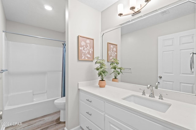 full bathroom featuring vanity, toilet, shower / bath combo with shower curtain, a textured ceiling, and wood-type flooring