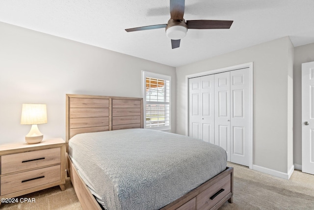 bedroom with light colored carpet, a closet, and ceiling fan