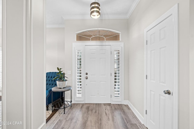 foyer with light hardwood / wood-style floors and crown molding