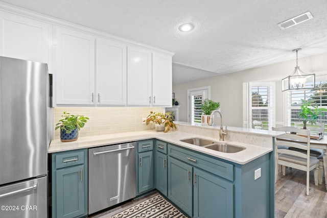 kitchen with white cabinetry, kitchen peninsula, sink, and appliances with stainless steel finishes