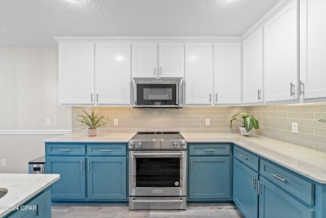 kitchen with stainless steel appliances, blue cabinets, white cabinetry, and light hardwood / wood-style floors