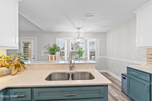 kitchen with sink, white cabinets, and light hardwood / wood-style floors