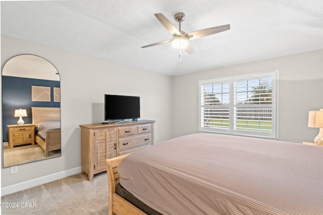 carpeted bedroom with a textured ceiling and ceiling fan