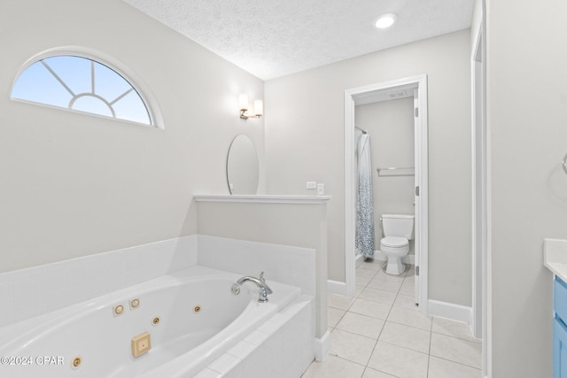 bathroom with vanity, tile patterned flooring, toilet, a textured ceiling, and tiled bath