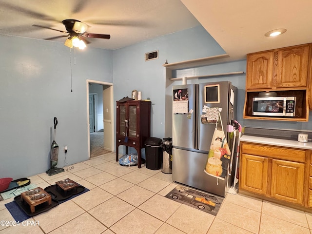 kitchen with ceiling fan, light tile patterned floors, and stainless steel appliances