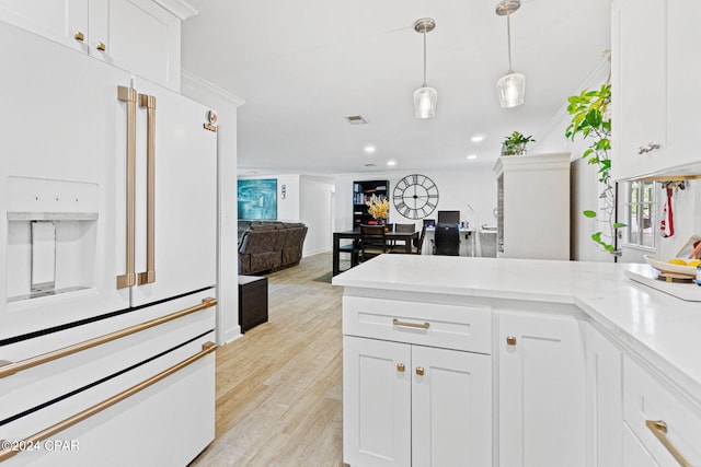 kitchen with white fridge with ice dispenser, white cabinets, pendant lighting, and light wood-type flooring