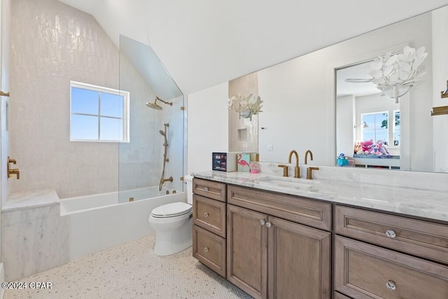 full bathroom featuring a wealth of natural light, toilet, vanity, and tiled shower / bath