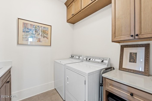 laundry area featuring cabinets, separate washer and dryer, and light tile patterned floors