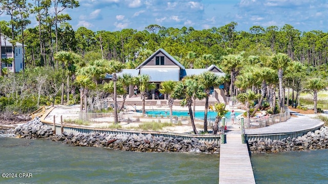 dock area featuring a water view, a patio area, and a community pool