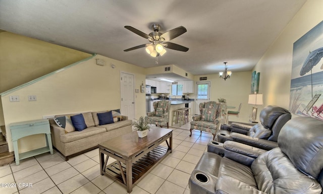 living room featuring light tile patterned floors and ceiling fan with notable chandelier