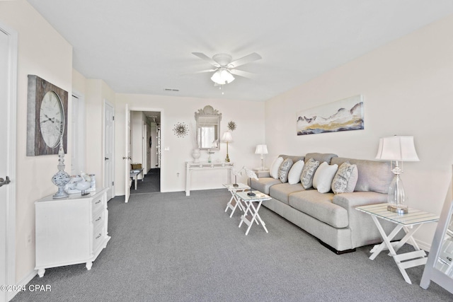 living room featuring dark colored carpet and ceiling fan