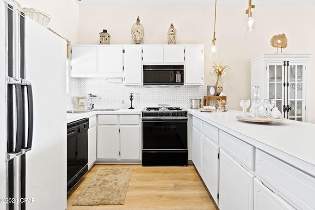 kitchen featuring decorative backsplash, sink, black appliances, white cabinets, and light hardwood / wood-style floors