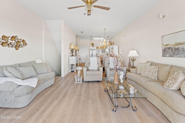 living room with ceiling fan with notable chandelier and light hardwood / wood-style floors