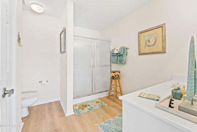 bathroom featuring toilet, hardwood / wood-style floors, and walk in shower