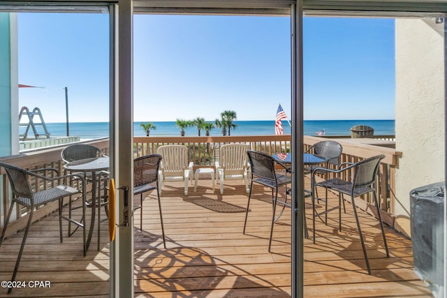 sunroom featuring a water view