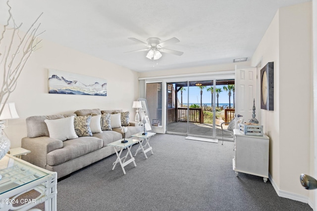 living room with ceiling fan and dark colored carpet