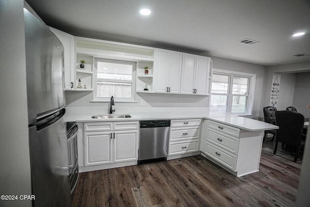 kitchen featuring kitchen peninsula, sink, white cabinets, and appliances with stainless steel finishes