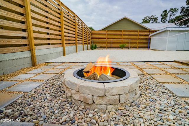 view of patio with a fire pit and a storage shed