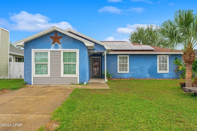 view of front of home featuring solar panels and a front lawn