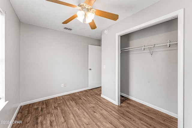 unfurnished bedroom featuring hardwood / wood-style flooring, ceiling fan, and a closet