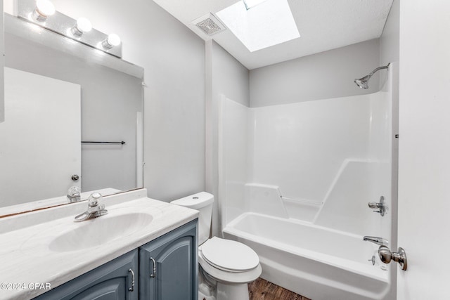 full bathroom with vanity, bathing tub / shower combination, a skylight, toilet, and wood-type flooring