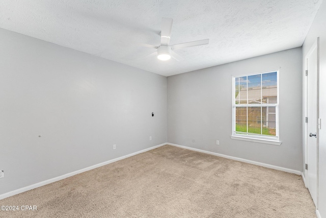 carpeted empty room featuring ceiling fan and a textured ceiling