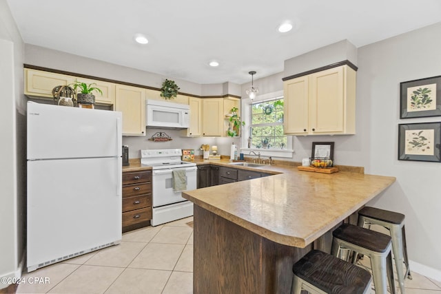 kitchen featuring sink, kitchen peninsula, cream cabinets, white appliances, and light tile patterned flooring