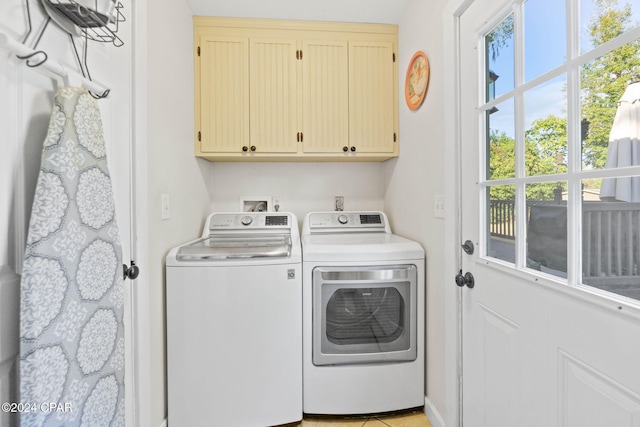 clothes washing area with cabinets and separate washer and dryer