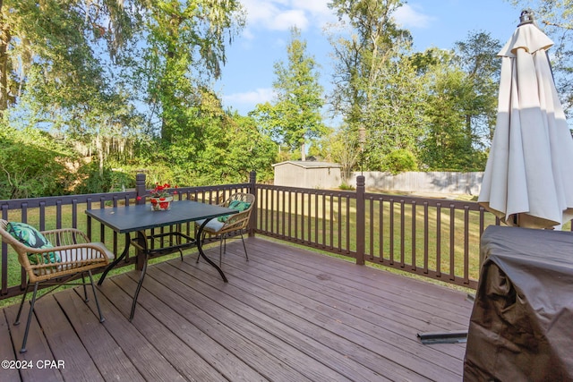 wooden terrace featuring a yard