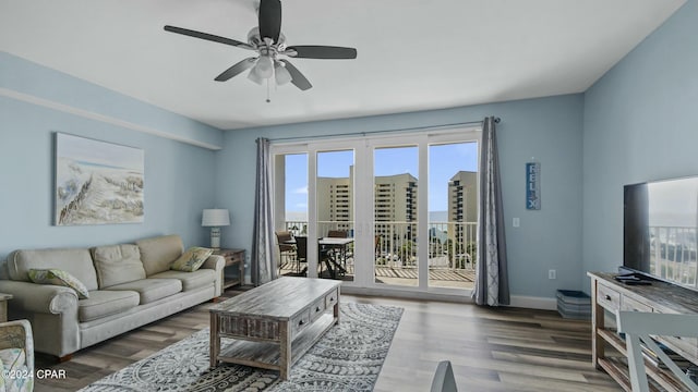 living room with dark hardwood / wood-style flooring and ceiling fan