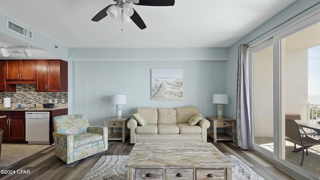 living room with dark hardwood / wood-style floors, ceiling fan, rail lighting, and a wealth of natural light