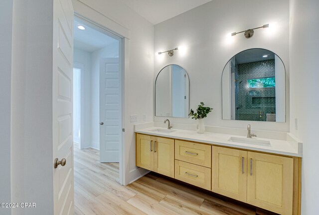 bathroom featuring hardwood / wood-style floors, vanity, and walk in shower