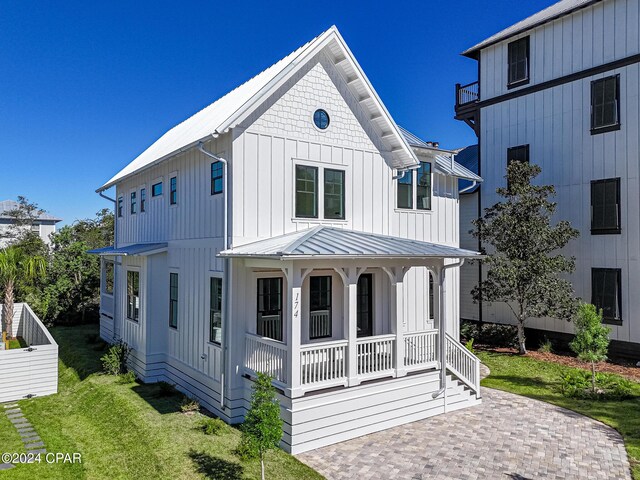 modern farmhouse style home with a front lawn and a porch