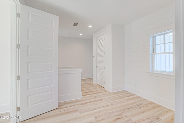 hall featuring wood walls and light hardwood / wood-style floors