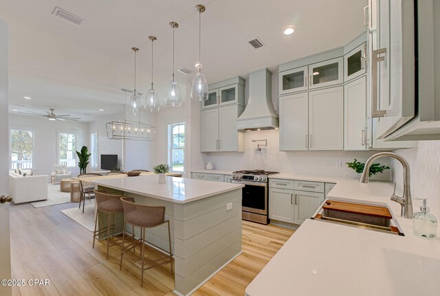 kitchen with a center island, white cabinets, hanging light fixtures, and appliances with stainless steel finishes