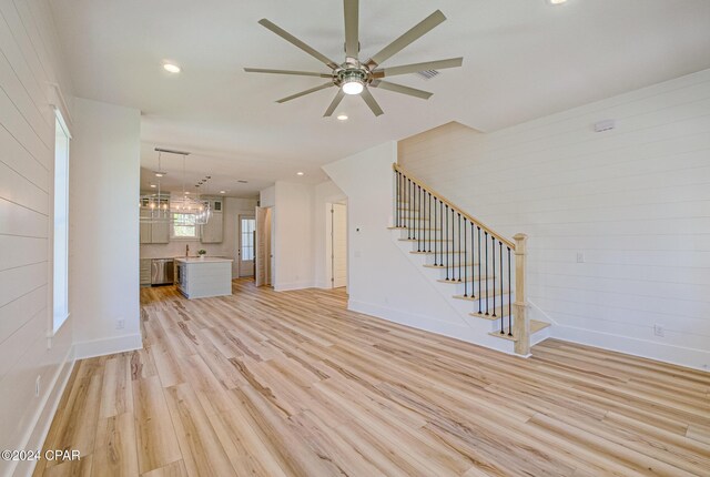 kitchen with pendant lighting, a center island, stainless steel appliances, and light hardwood / wood-style flooring