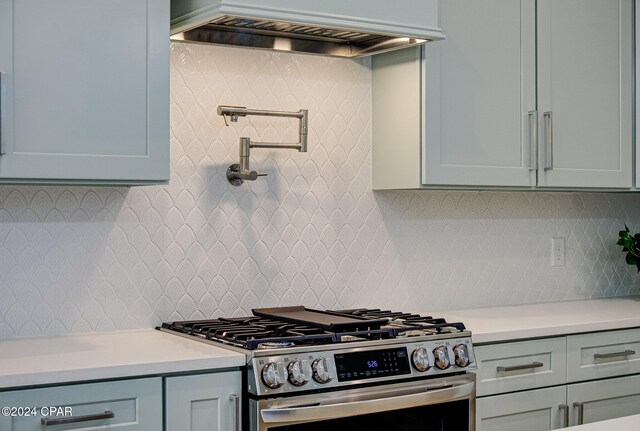 kitchen with gas stove, backsplash, and premium range hood