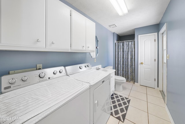 laundry room with independent washer and dryer, a textured ceiling, and light tile patterned flooring