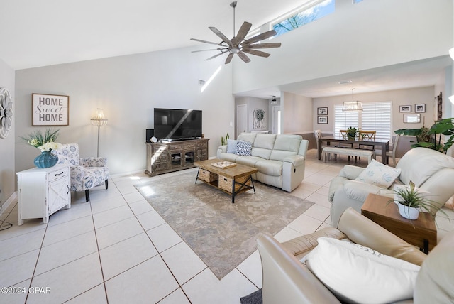 living room featuring ceiling fan with notable chandelier, light tile patterned floors, and high vaulted ceiling