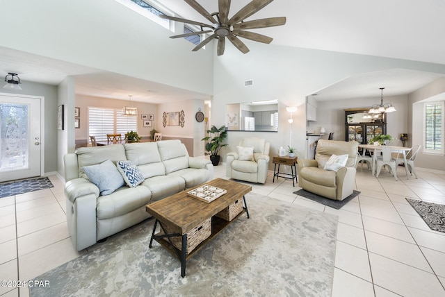 living room featuring light tile patterned floors, ceiling fan with notable chandelier, and high vaulted ceiling