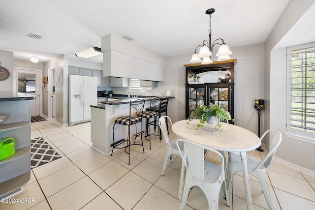 tiled dining space featuring a notable chandelier