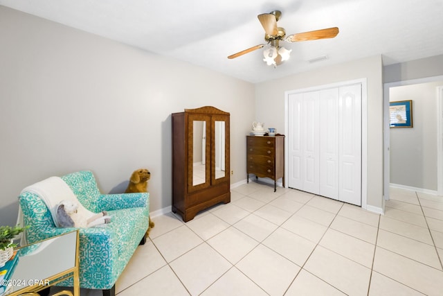 living area featuring ceiling fan and light tile patterned floors