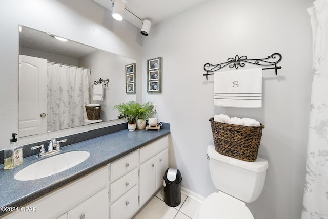 bathroom with toilet, vanity, and tile patterned floors